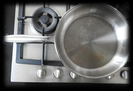 Zogenaamd titanium koekenpan op het gasfornuis van het restaurant tijdens het materiaalonderzoek
