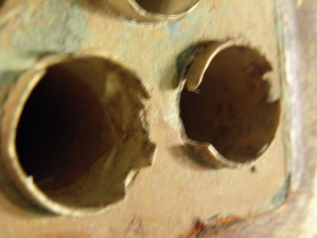 Close-up van pijpuiteinden die door erosiecorrosie in een scheepsevaporator deels zijn weggesleten